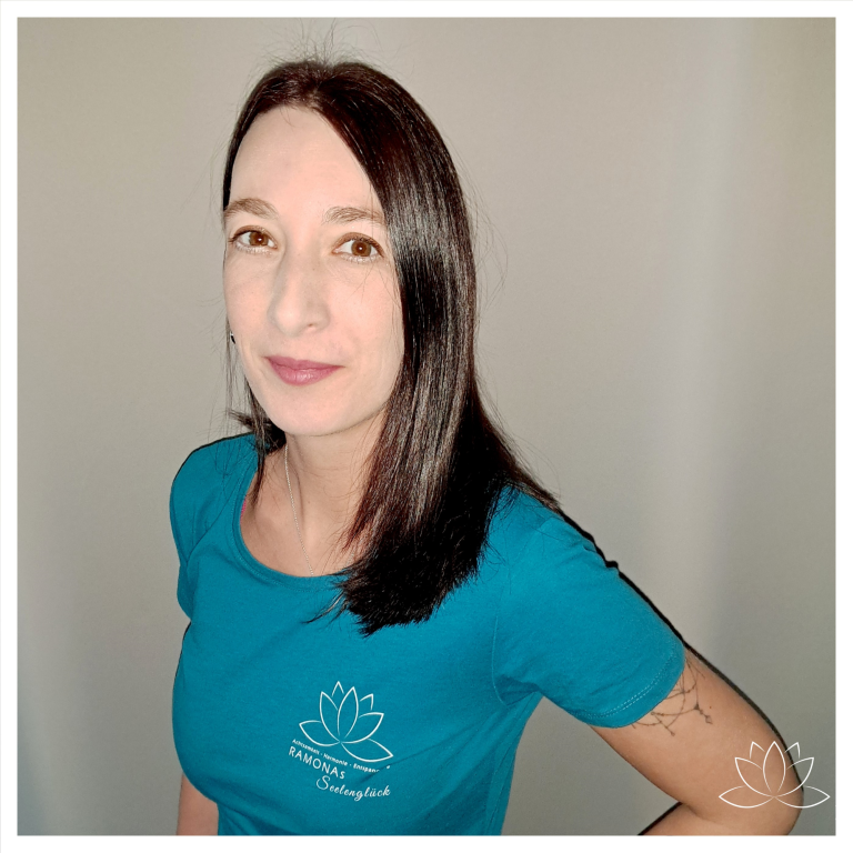Ramona Hieber Junge Frau mit langen, glatten Haaren, trägt ein blaues T-Shirt mit Lotusmotiv (Ramonas Seelenglück).