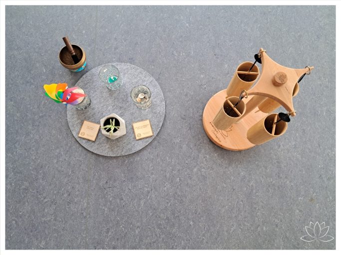 Ein runder Tisch mit bunten Accessoires und eine skulpturale Holzgestaltung.